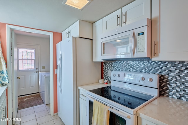 kitchen with white cabinetry, tasteful backsplash, white appliances, light tile patterned floors, and washer and dryer