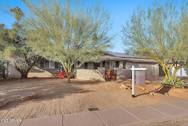 view of front of property featuring a garage and solar panels