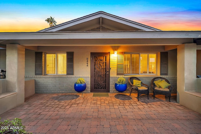 exterior entry at dusk with covered porch