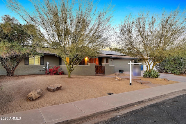 view of front of house with a garage and solar panels