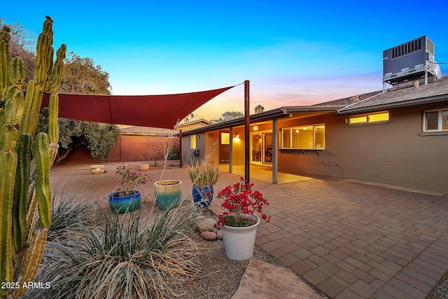 patio terrace at dusk featuring central AC