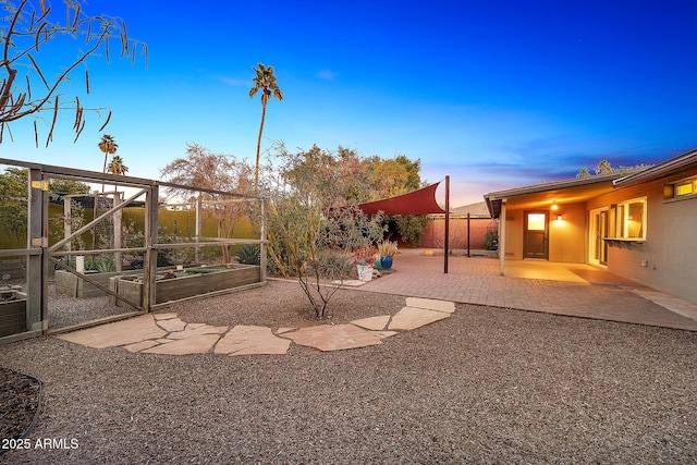 yard at dusk featuring a patio