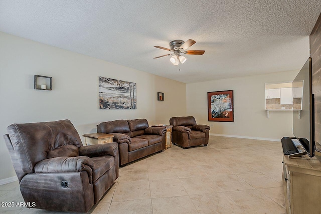 living area with baseboards, a textured ceiling, ceiling fan, and light tile patterned floors