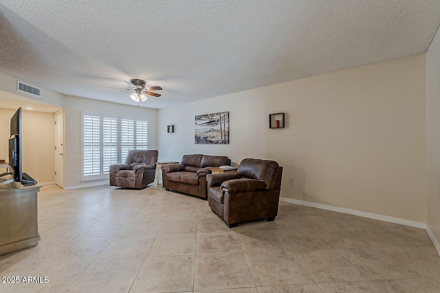 living room with visible vents, a textured ceiling, ceiling fan, and baseboards