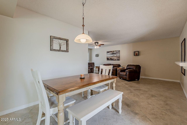 dining area with a textured ceiling, ceiling fan, and baseboards