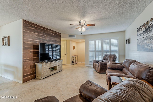 living area featuring light tile patterned floors, baseboards, ceiling fan, and visible vents