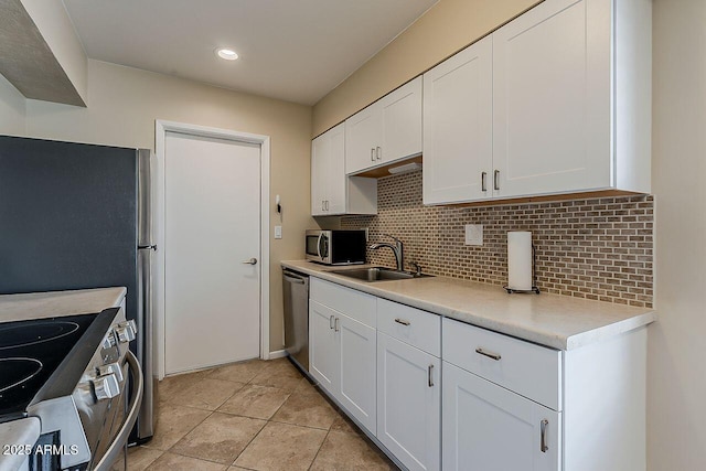 kitchen featuring a sink, light countertops, decorative backsplash, and stainless steel appliances