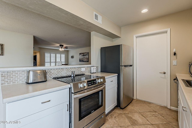 kitchen featuring backsplash, visible vents, appliances with stainless steel finishes, light countertops, and white cabinets