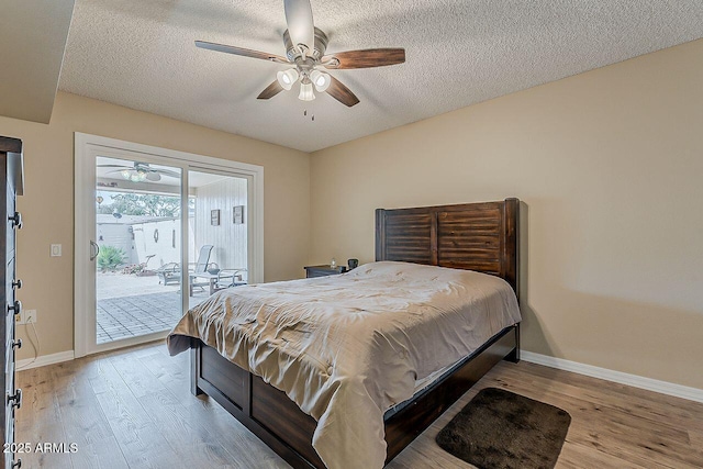 bedroom with light wood-style floors, access to outside, and a textured ceiling