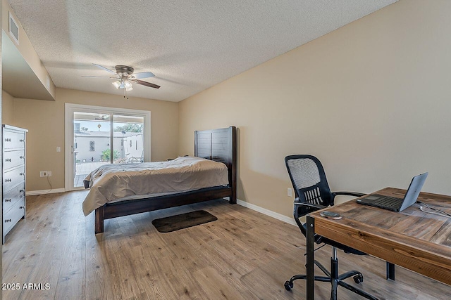 bedroom featuring access to outside, a textured ceiling, baseboards, light wood-type flooring, and visible vents
