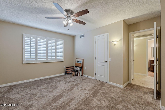 unfurnished bedroom with visible vents, carpet flooring, a textured ceiling, and a ceiling fan