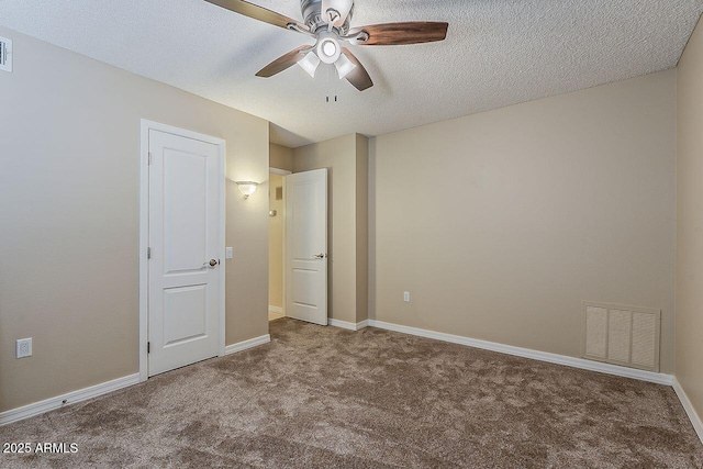 unfurnished bedroom featuring visible vents, a textured ceiling, carpet, and baseboards