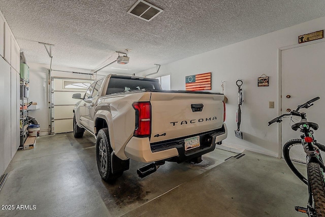 garage with visible vents and a garage door opener
