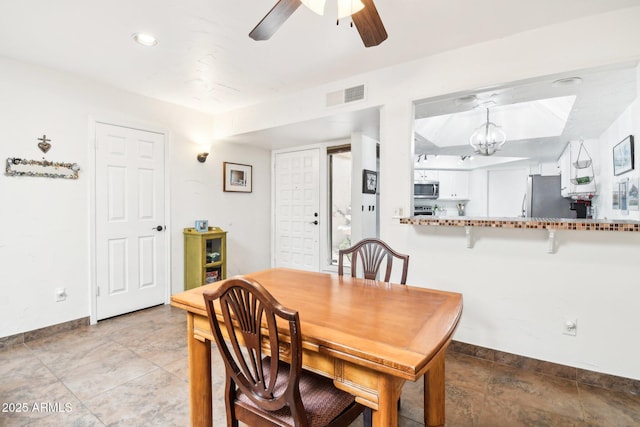 dining room with ceiling fan with notable chandelier