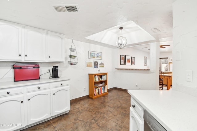 kitchen with dishwasher, ceiling fan with notable chandelier, pendant lighting, and white cabinets