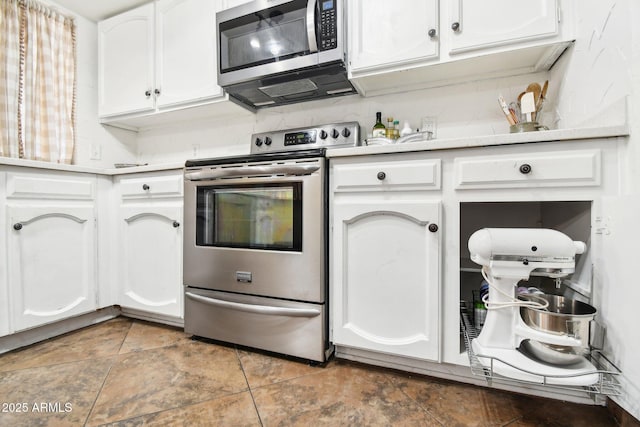 kitchen with white cabinetry, appliances with stainless steel finishes, tile patterned flooring, and decorative backsplash