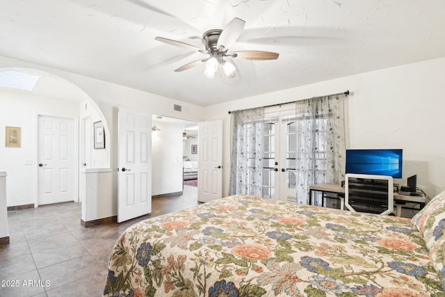 tiled bedroom with french doors and ceiling fan