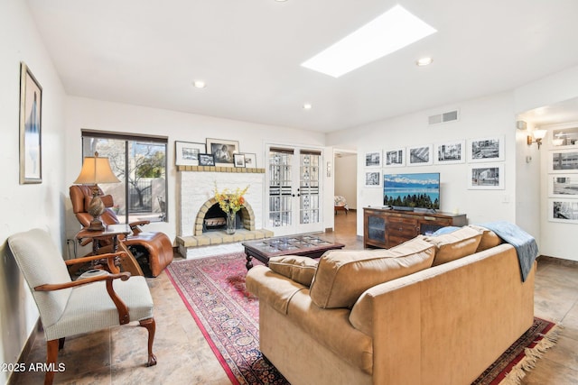 living room with a brick fireplace and a skylight