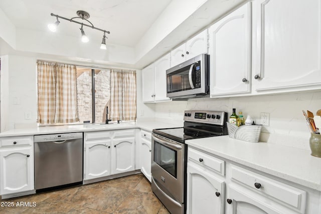 kitchen with appliances with stainless steel finishes, sink, and white cabinets