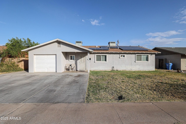 single story home featuring a front yard, solar panels, and a garage