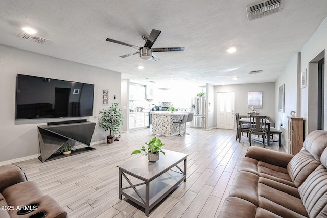 living room featuring a textured ceiling and ceiling fan