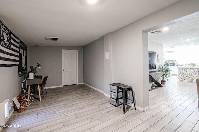 interior space featuring a textured ceiling and light hardwood / wood-style flooring