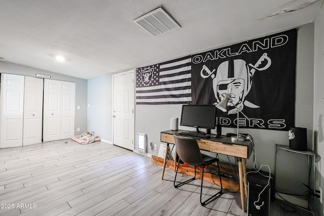 home office with light hardwood / wood-style floors