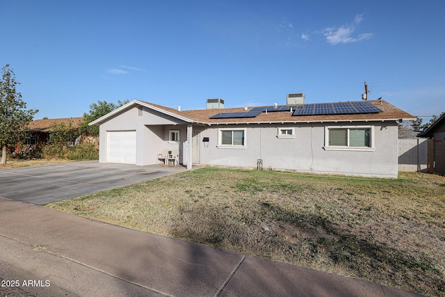 ranch-style home with solar panels, a garage, and a front yard