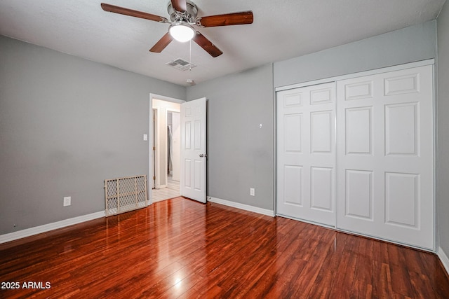 unfurnished bedroom with wood-type flooring, a closet, and ceiling fan