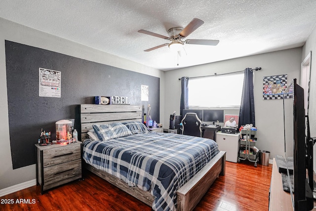 bedroom featuring a textured ceiling, ceiling fan, and dark hardwood / wood-style floors