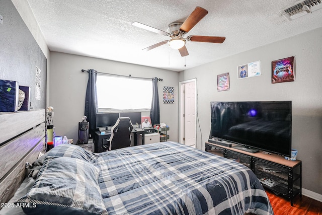 bedroom featuring ceiling fan, dark hardwood / wood-style flooring, and a textured ceiling