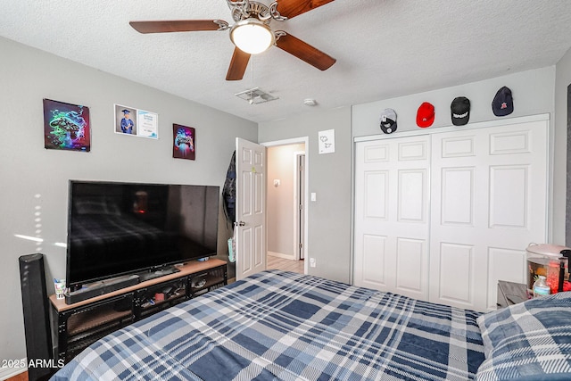 bedroom with ceiling fan, a textured ceiling, and a closet