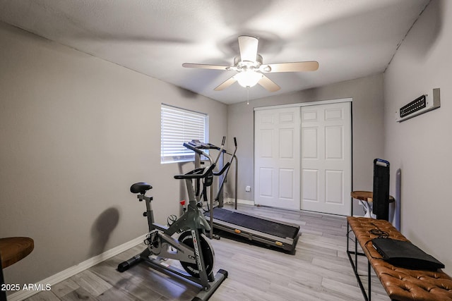 exercise area with ceiling fan and light hardwood / wood-style floors