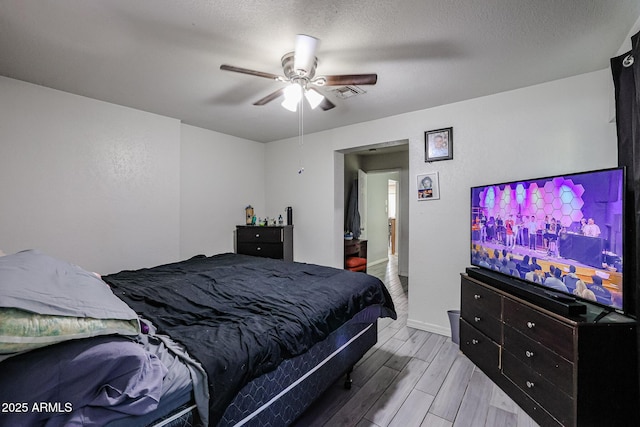 bedroom with ceiling fan and a textured ceiling