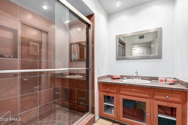 bathroom with tile patterned flooring, vanity, and a shower with shower door