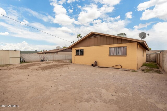 rear view of house with a fenced backyard