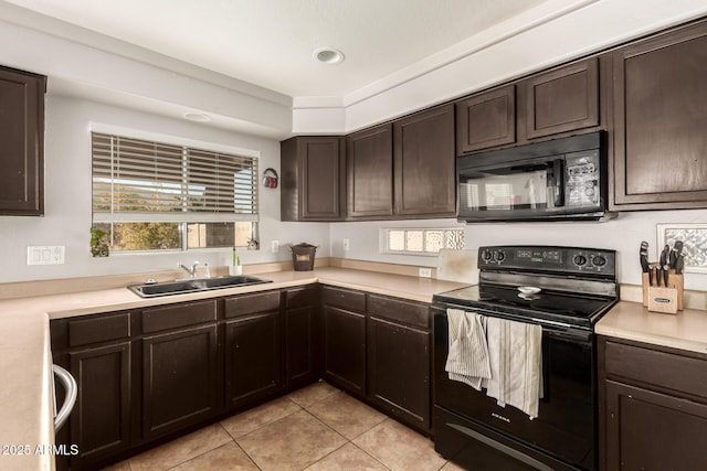 kitchen with light tile patterned flooring, dark brown cabinetry, sink, and black appliances