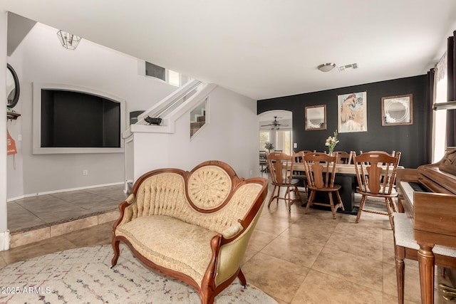 living area with ceiling fan and tile patterned flooring