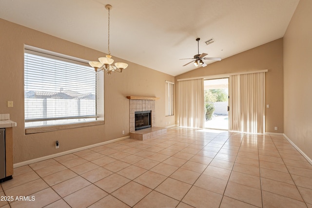 unfurnished living room featuring ceiling fan with notable chandelier, light tile patterned flooring, vaulted ceiling, and a tiled fireplace