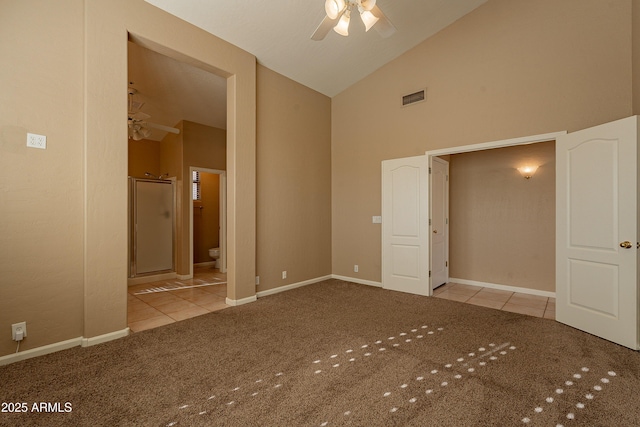 unfurnished bedroom featuring ensuite bathroom, high vaulted ceiling, light carpet, and ceiling fan