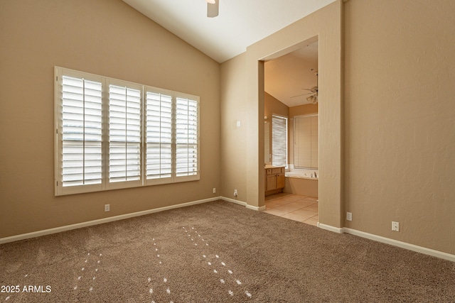 empty room featuring ceiling fan, light colored carpet, and lofted ceiling