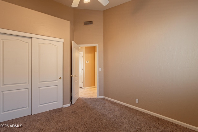 unfurnished bedroom with light colored carpet, a closet, and ceiling fan