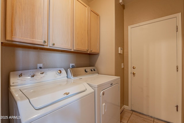 laundry area with cabinets, separate washer and dryer, and light tile patterned flooring