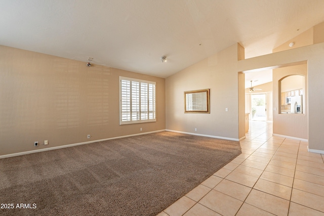 tiled empty room featuring ceiling fan and vaulted ceiling