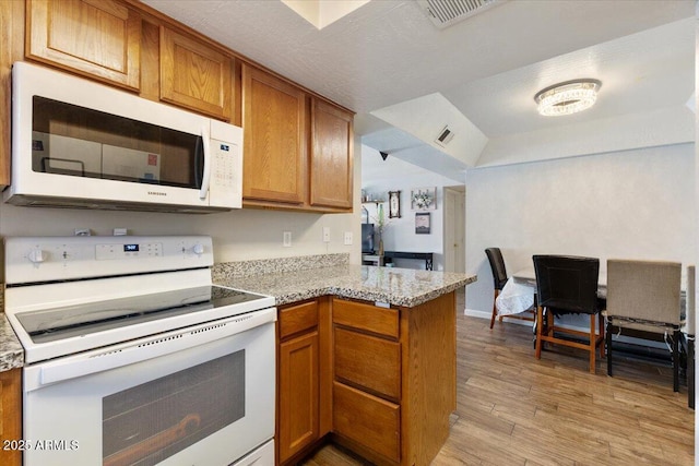 839 S Westwood Unit 154, Mesa, AZ 85210 - kitchen featuring white appliances, light wood-type flooring, brown cabinets, a peninsula, and open floor plan