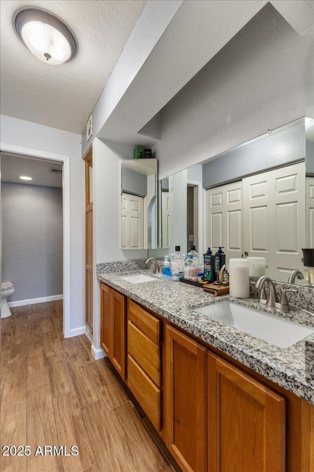 839 S Westwood Unit 154, Mesa, AZ 85210 - full bath with double vanity, wood finished floors, baseboards, and toilet