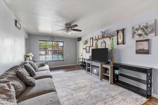 839 S Westwood Unit 154, Mesa, AZ 85210 - living area featuring wood finished floors, ceiling fan, a textured ceiling, baseboards, and a textured wall