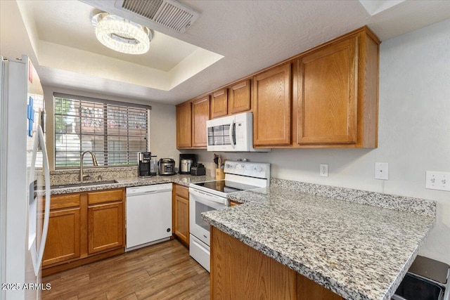 839 S Westwood Unit 154, Mesa, AZ 85210 - kitchen featuring white appliances, a sink, a peninsula, light wood-style flooring, and brown cabinetry