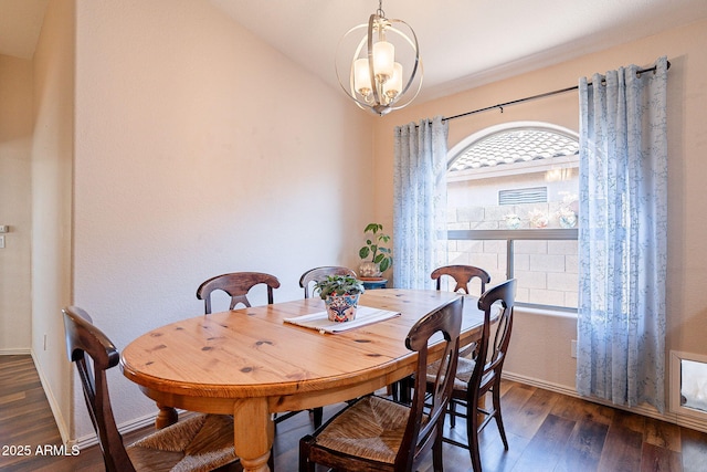 dining room with dark hardwood / wood-style flooring and an inviting chandelier