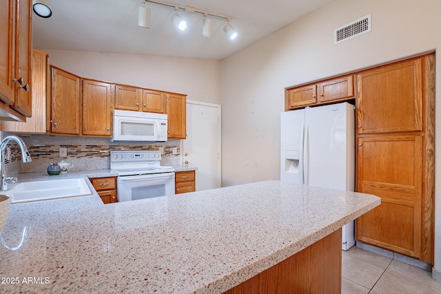 kitchen with lofted ceiling, kitchen peninsula, decorative backsplash, sink, and white appliances